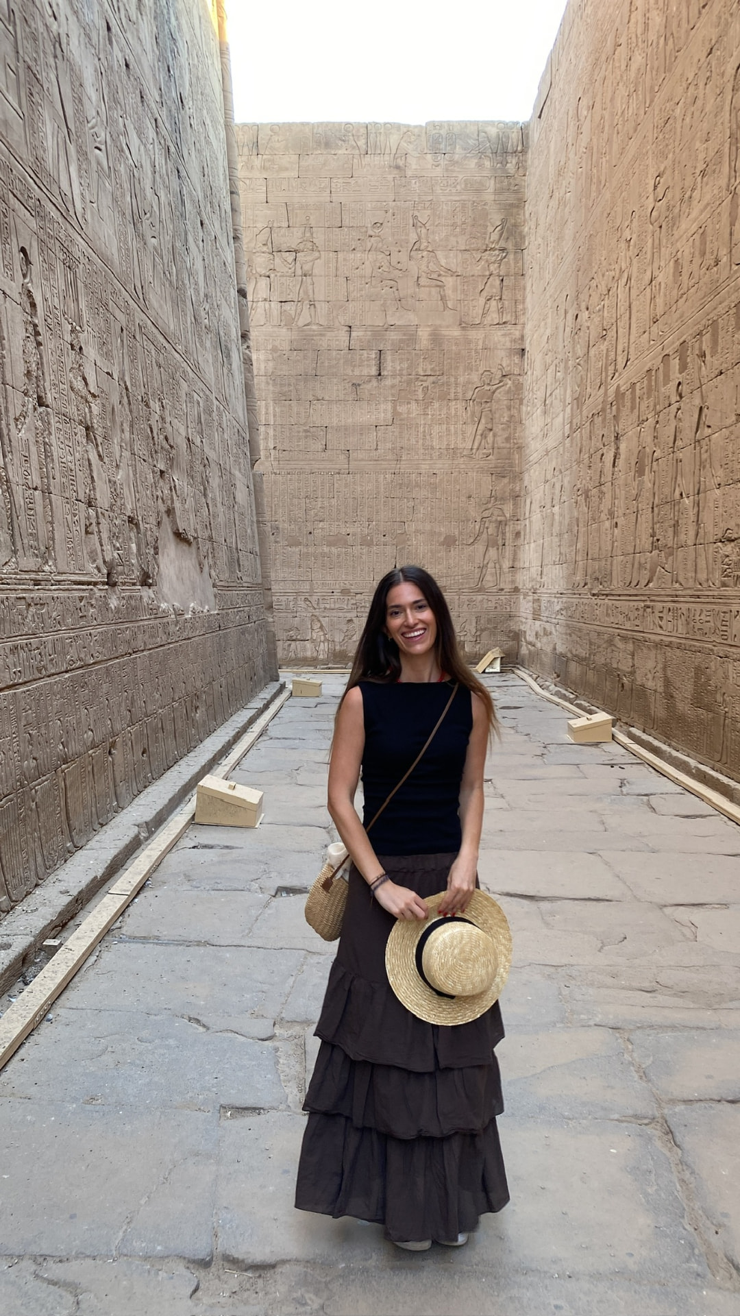 Retrato de la creadora sonriendo en un templo egipcio con un sombrero de paja
